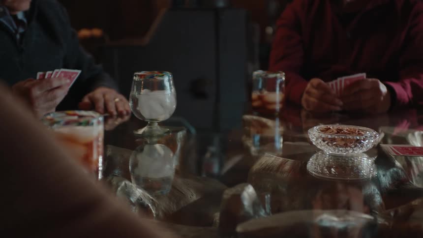 People sitting around a glass table playing cards