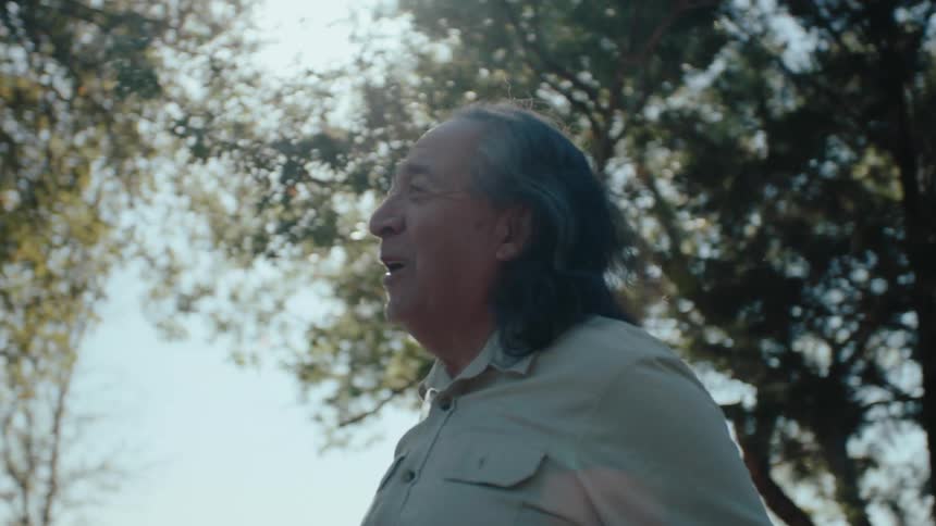 A footage of an elderly man raising his hands in a joyful manner
