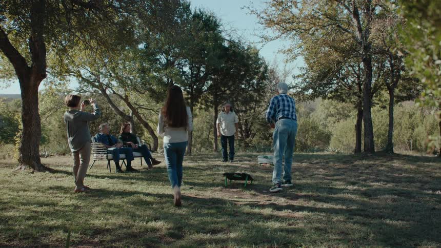 Family gathered in a garden talking and playing