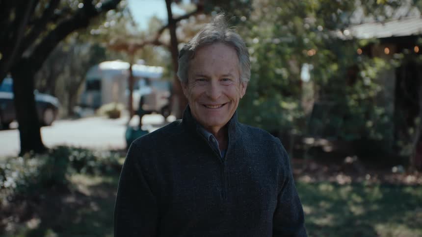 Portrait of an elderly man smiling in a backyard