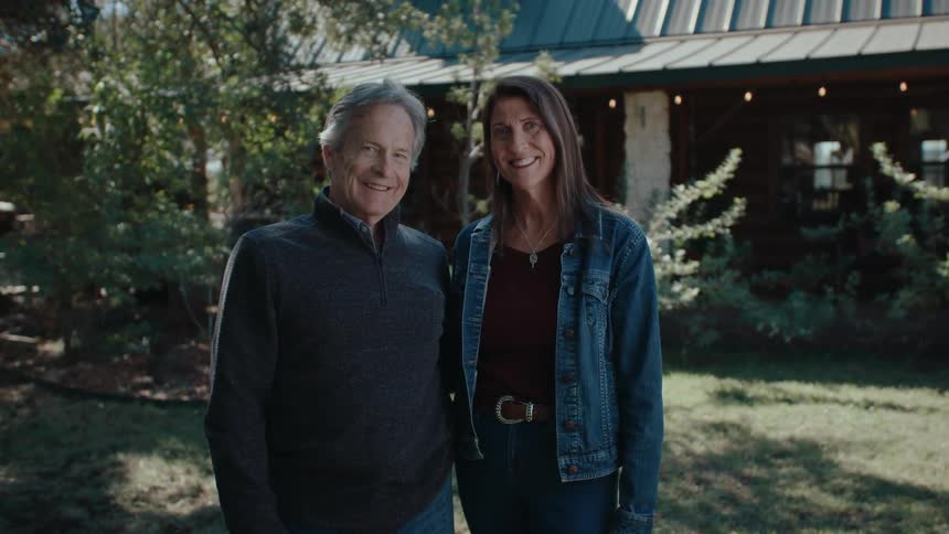 A man and woman smile in the yard
