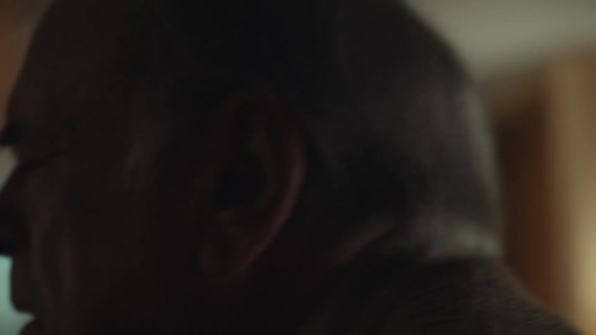Portrait of an elderly man with a dejected facial expression walking towards the door