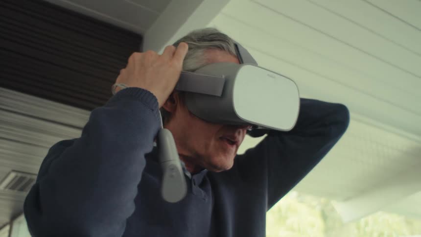 White man indoors setting a vr headset over his face during daytime