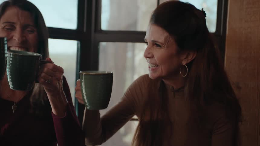 Friends holding and raising mugs in a toast