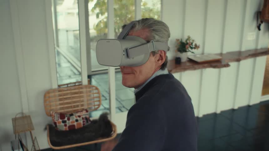 A person wearing a virtual reality headset playing a game in a room