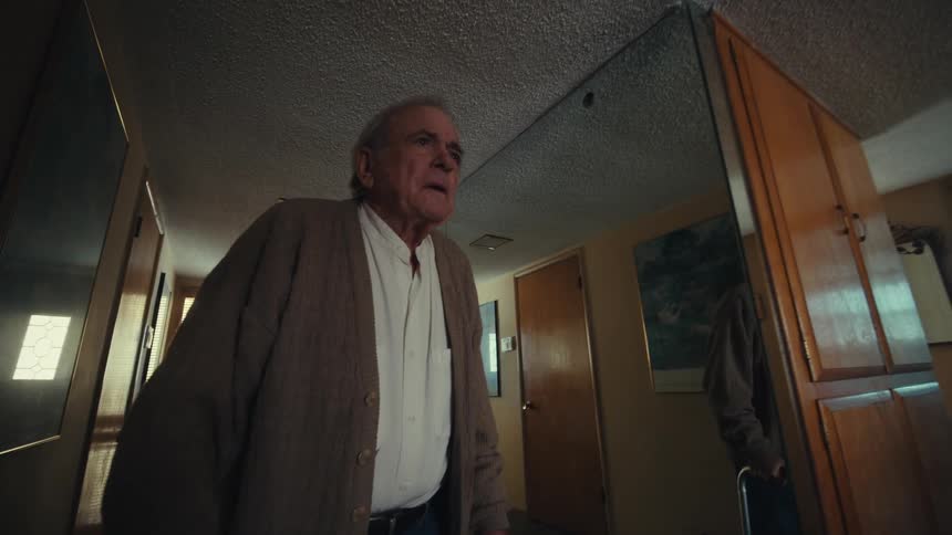 Elderly man walking around the house with the help of a walker