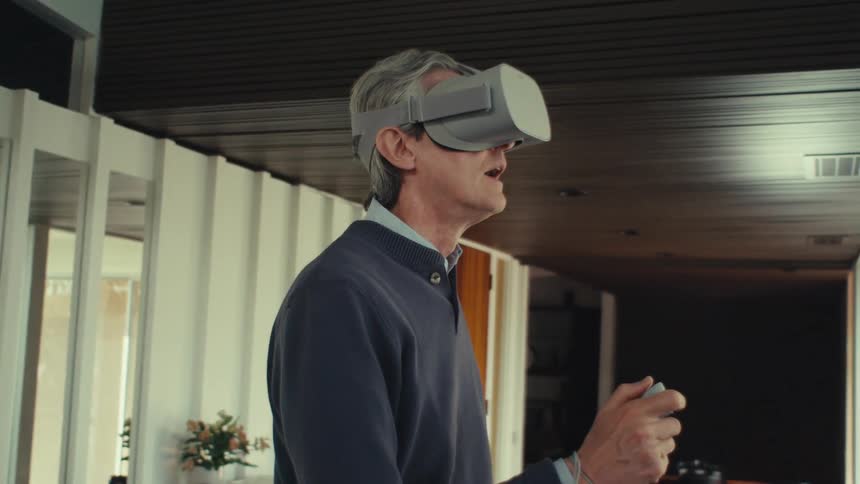 Man standing inside house interacting with virtual reality glasses