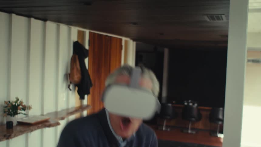 A person wearing a virtual reality headset playing a game in a room