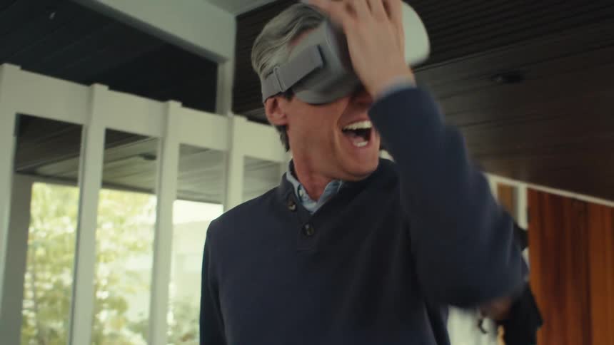 Man indoors having fun using virtual reality glasses