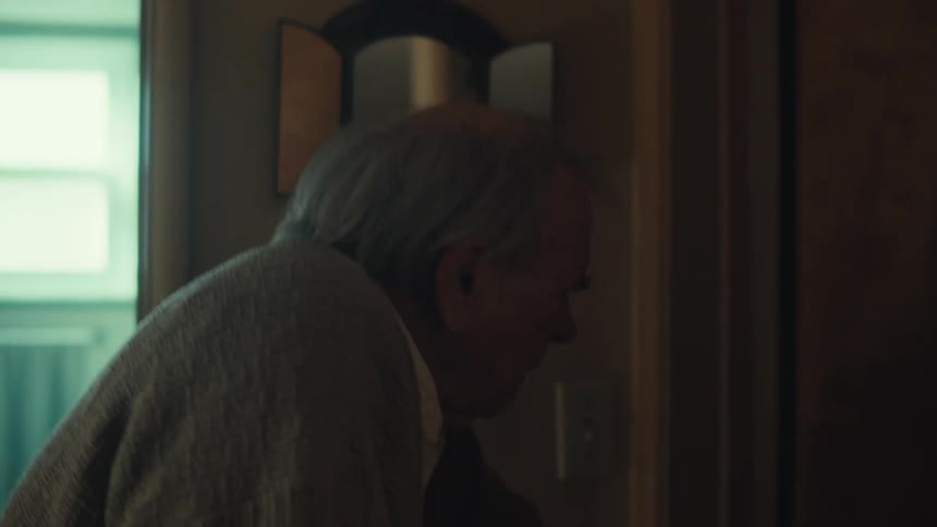 Elderly man walking indoors and entering a room
