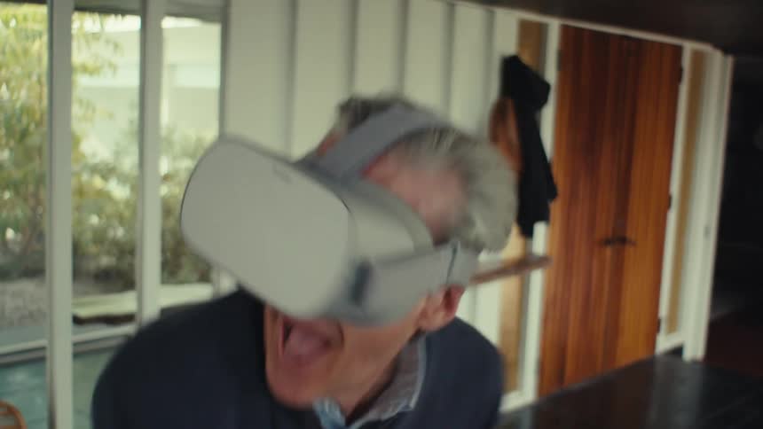 Close up of a man wearing a virtual reality headset and playing a video game