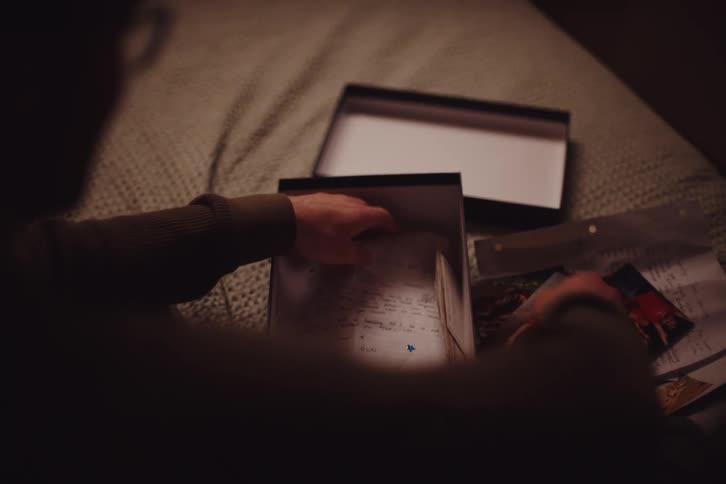 A person holds a photo of two children and then a letter evoking nostalgia