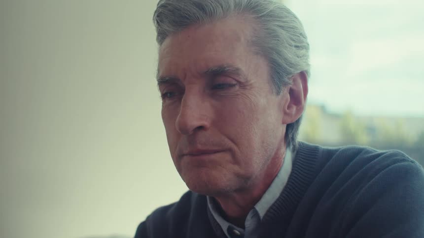 An image of an elderly man smiling and thinking