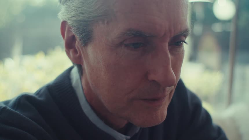 A close up of an older man looking pensive and thoughtful