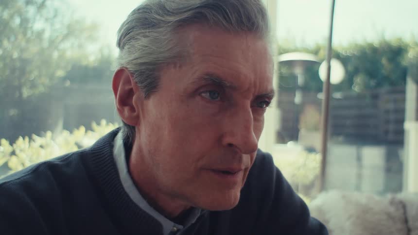 Man sitting staring straight ahead and thoughtful