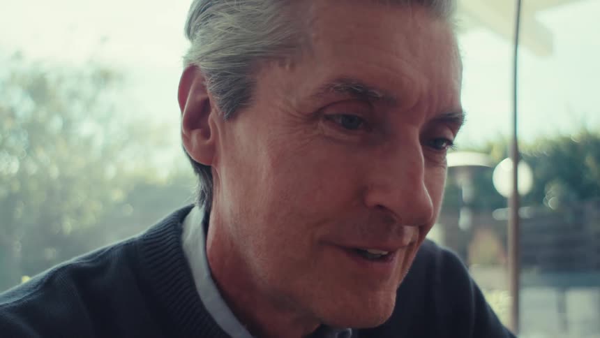 The face of a grayhaired man who is nodding his head in confirmation tones and he has a subtle smile on his face