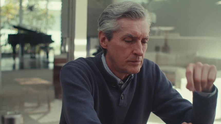 Man sitting in an outdoor area of the house thinking