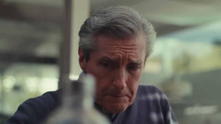Man sitting drinking a glass of water and talking