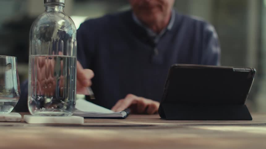 Man talking in front of a tablet and a little dissatisfied making gestures with his hands