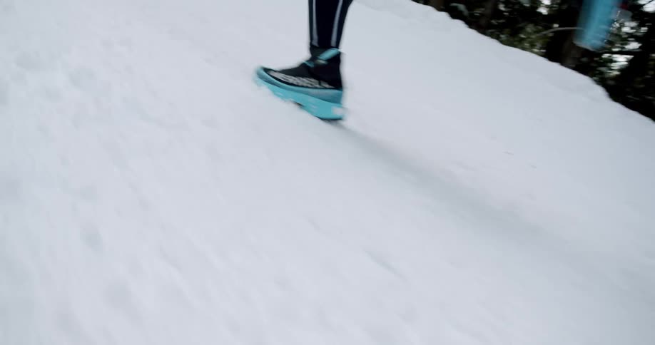 Legs of a person running in the snow