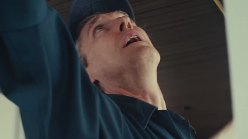 A man measures the ceiling with a tape measure
