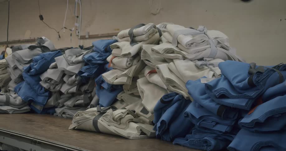 Stacks of folded fabrics on a table with predominant colors blue and white
