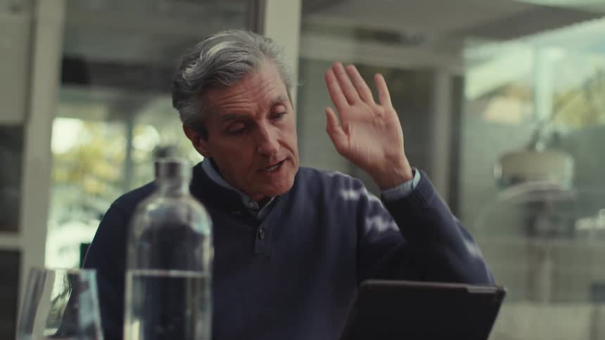 A man in an office tells someone to push and push in a conversation hes having through a tablet