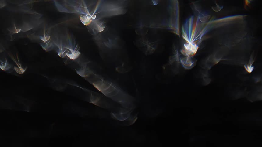 Extreme close up on an abstract black background with reflection of bright lights