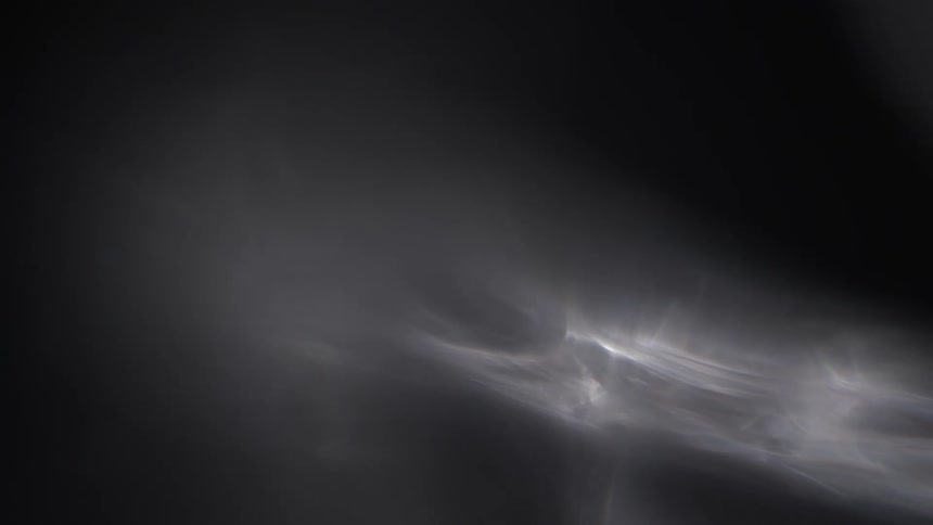 A plume of smoke moving against a dark backdrop