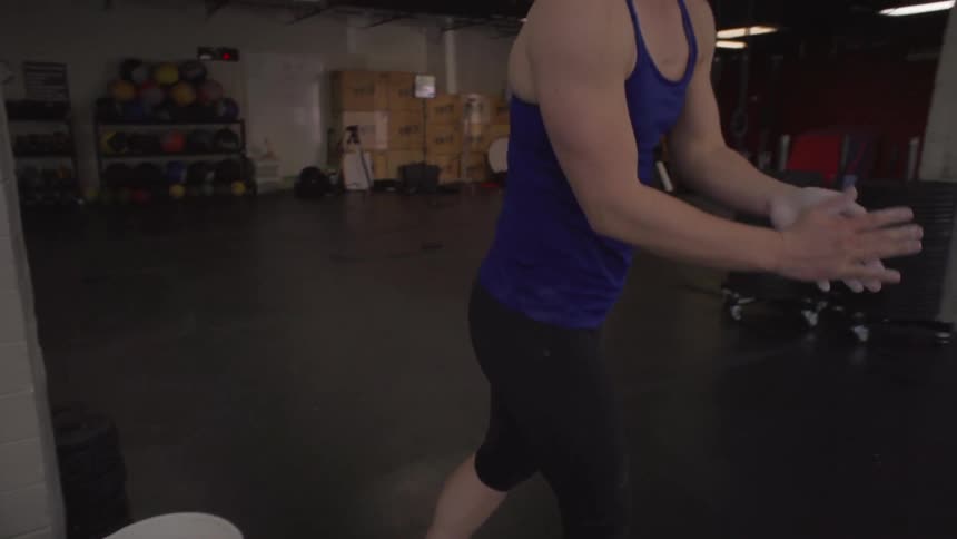 Woman wiping her hands together in a bucket before going to gym floor