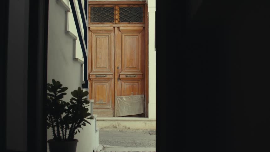 A wooden door with a motorcycle passing by in the foreground