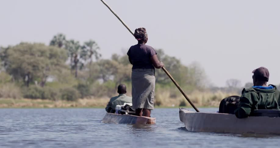 People are rowing two small boats across the river