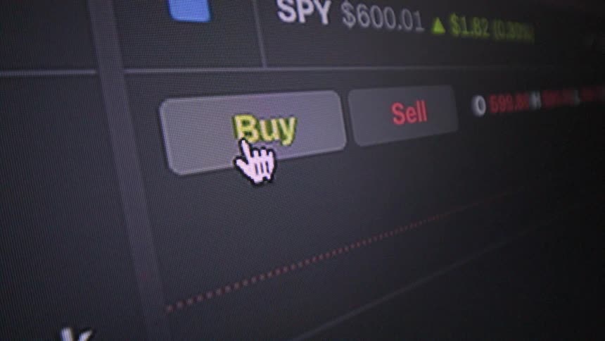 Close up of a screen with a mouse pointer clicking buy on a financial market platform