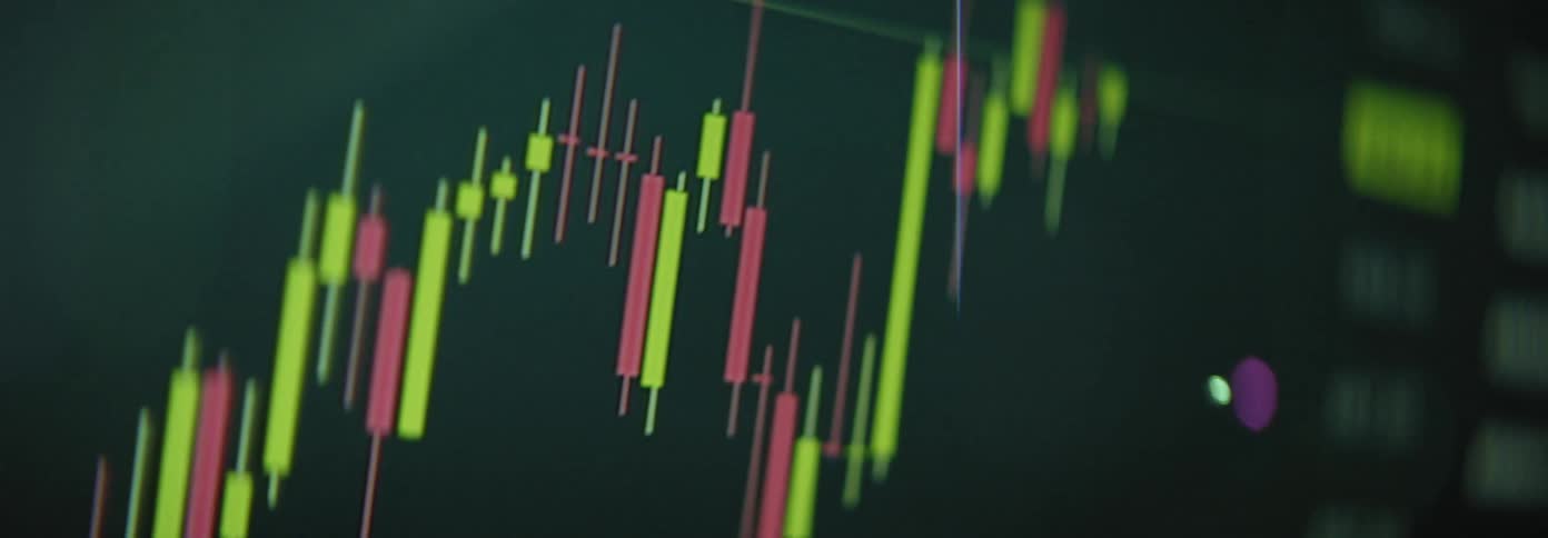 A closeup view of a stock market chart with red and green candlesticks fluctuating