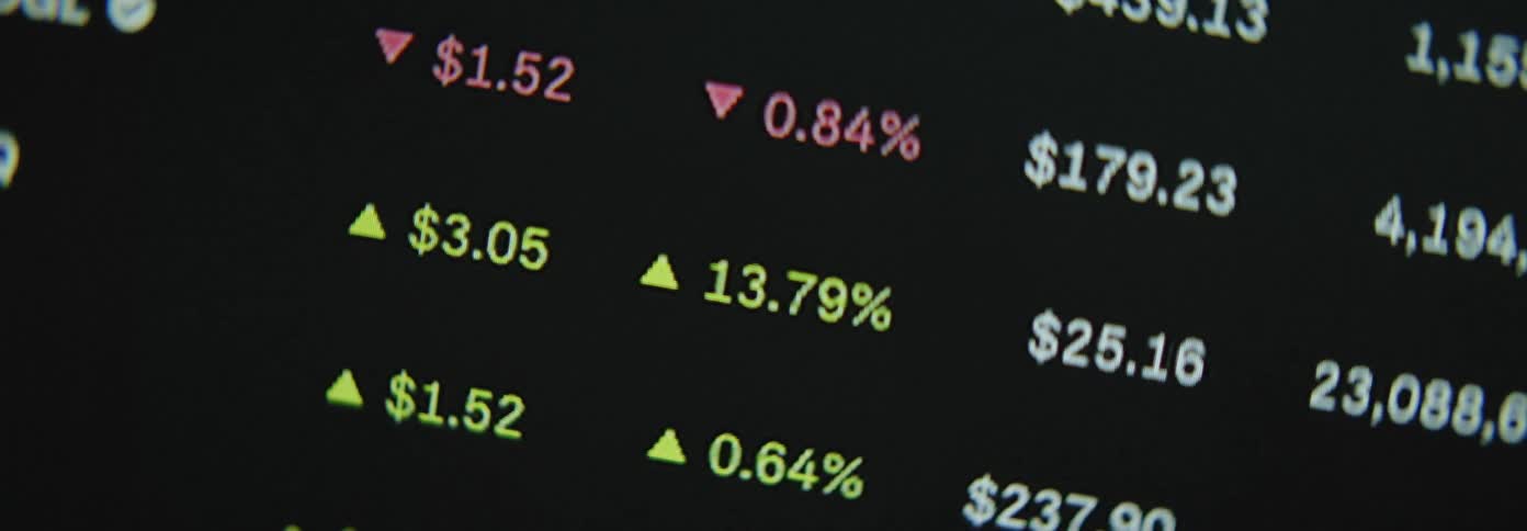 A digital display showing stock market gains and losses in red and green