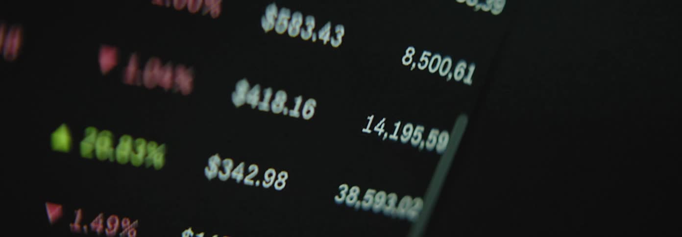 A screen displaying fluctuating stock market numbers in focus