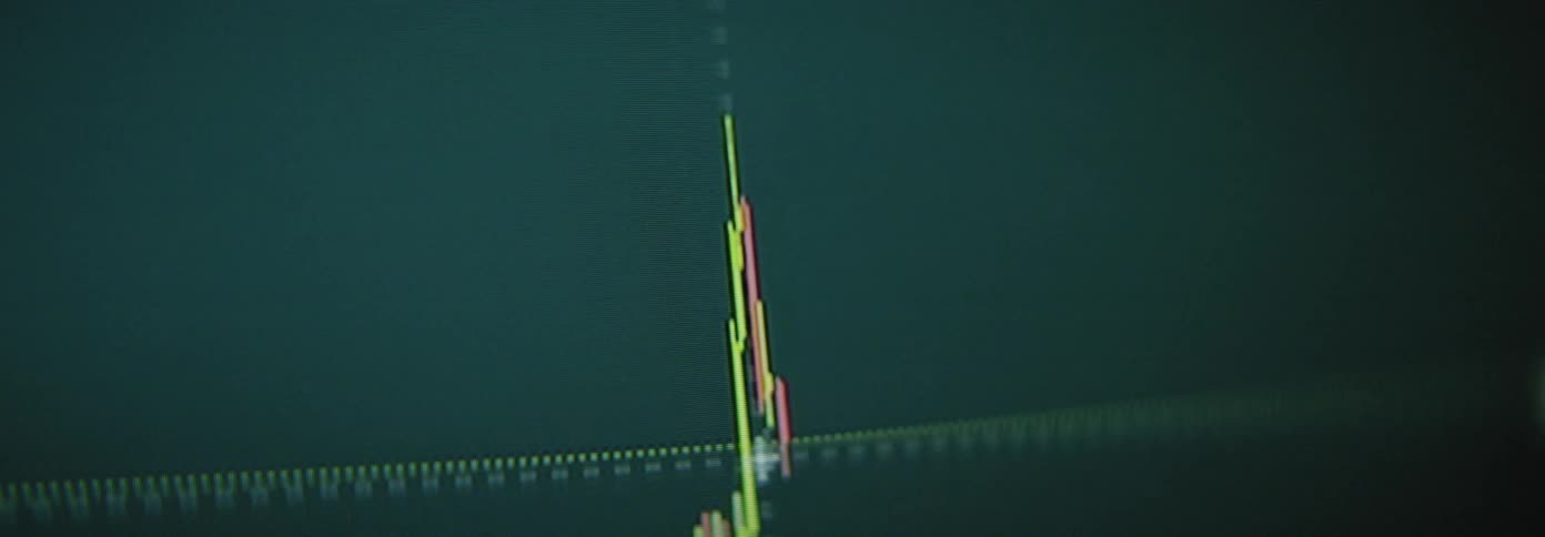 A black screen with a trading chart with green and red lines going up and down