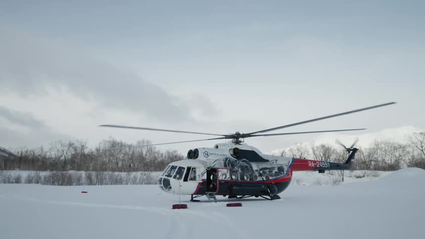 A helicopter is starting up on the snow