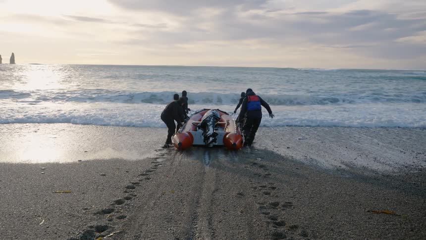 A clip of people pushing a boat into the sea
