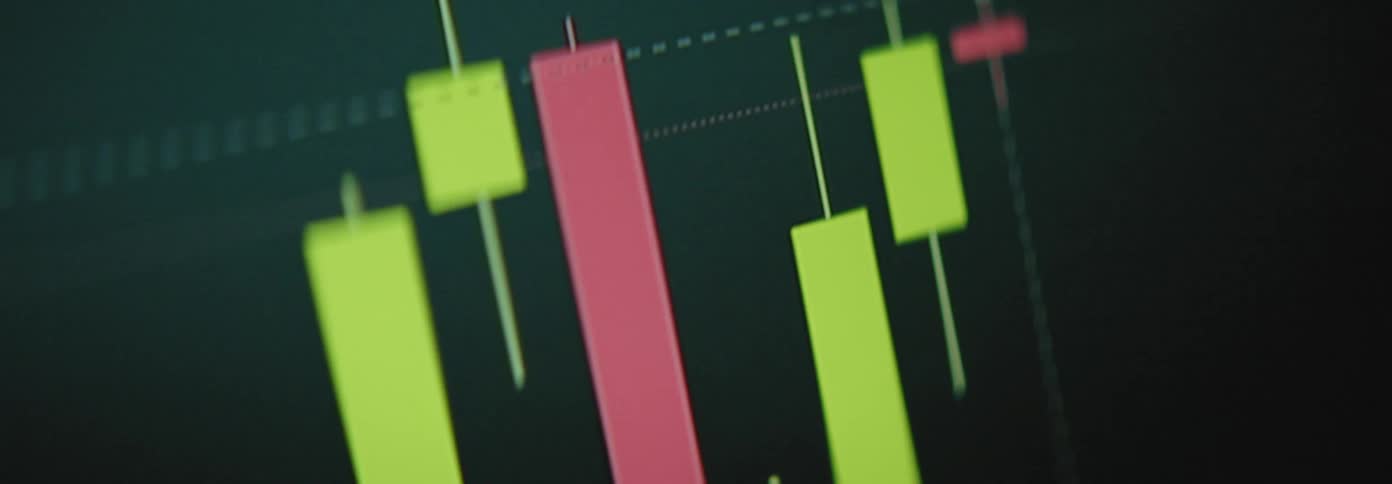 A closeup view of a stock market chart with red and green candlesticks fluctuating