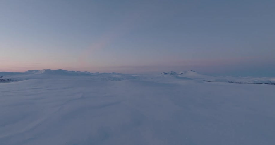 The landscape is covered in snow at sunrise