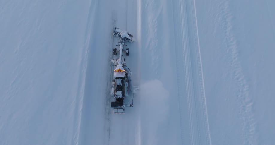 An aerial view of a snowplow clearing a snowy path