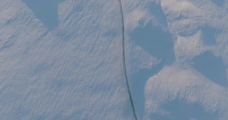 A small trail runs through the snow