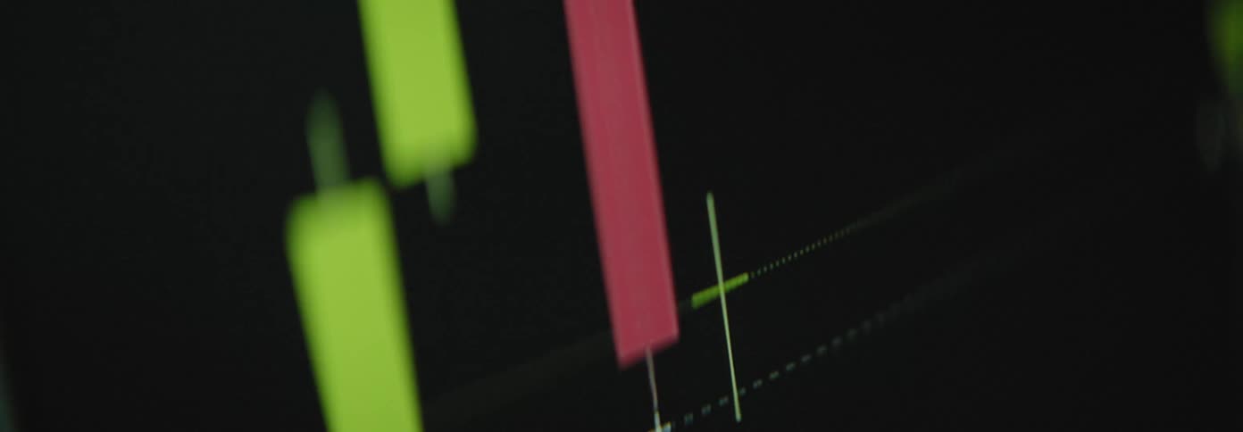 A closeup view of a stock market chart with red and green candlesticks fluctuating