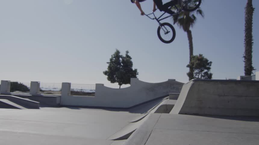 A bicyclist jumps on a ramp in a skate park