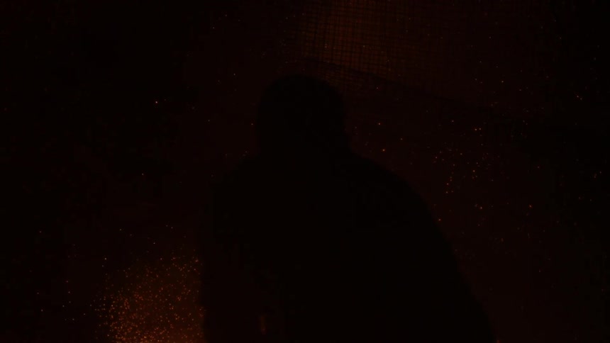 Firework sparks fly around a silhouetted man