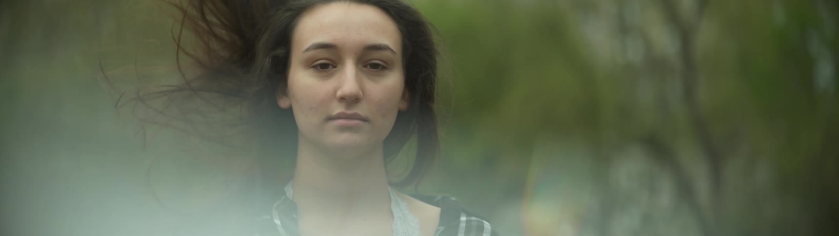 A woman standing there and her hair is flipping and blowing