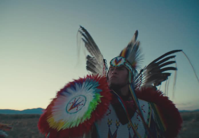 Man wearing native american attire in an outdoor setting