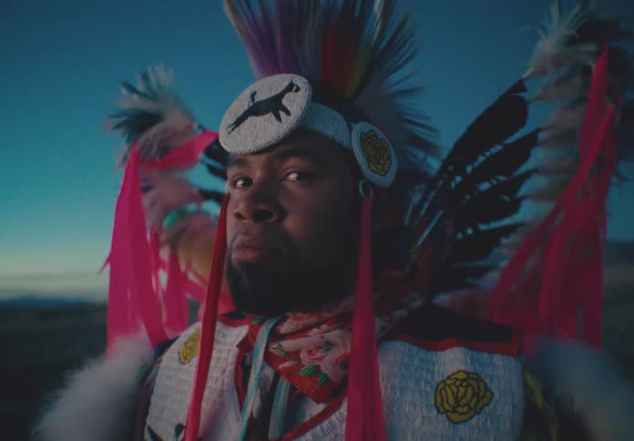 Portrait of a man with a serious expression wearing native american attire