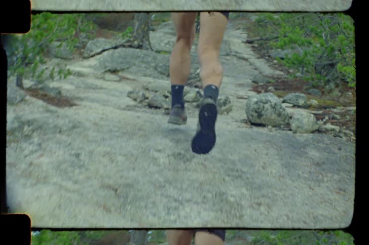 Legs of a man running up a mountain